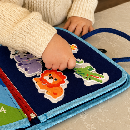 Toddler hands playing with Montessori Busy Board animal puzzles